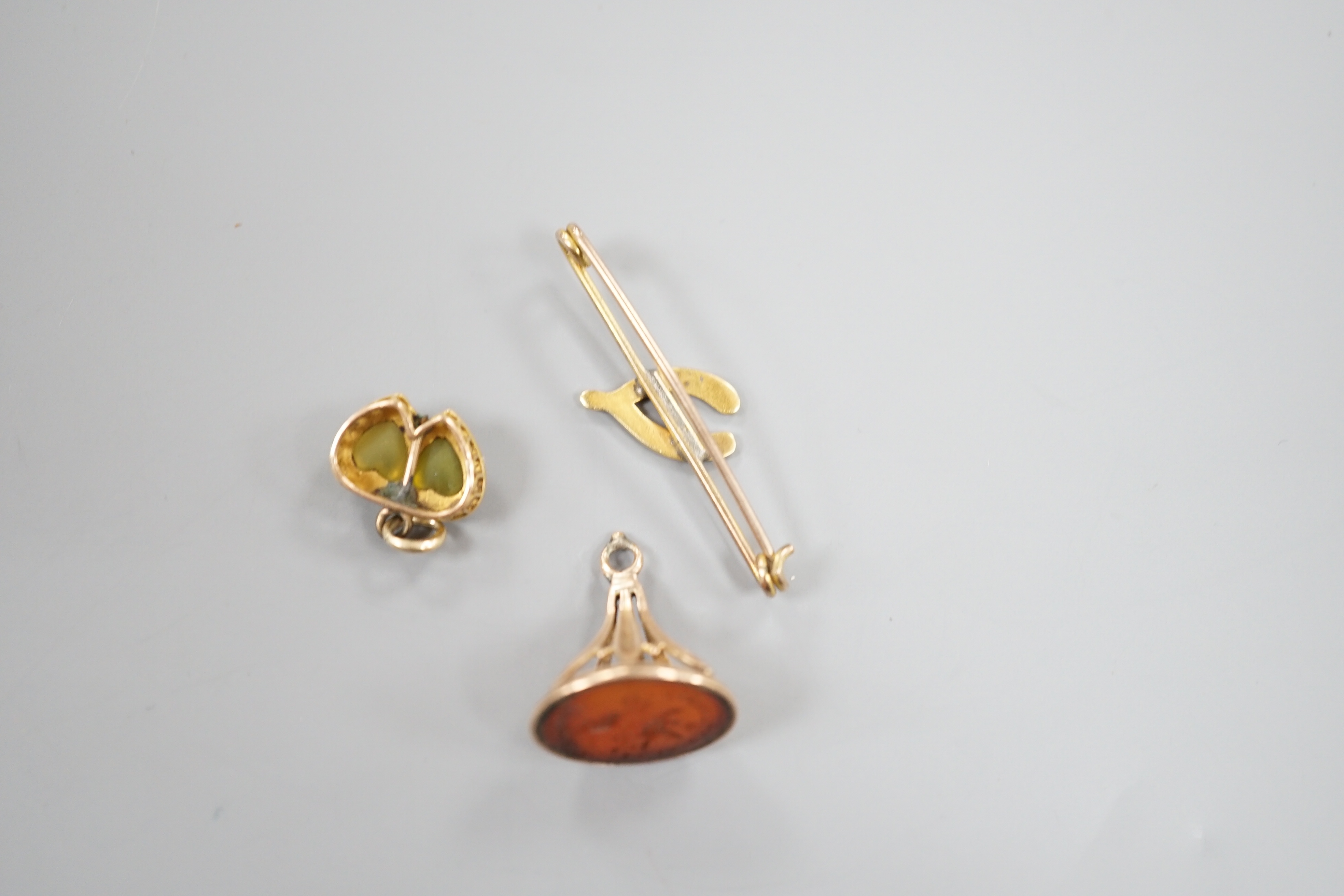 A yellow metal olivine? and seed pearl set twin heart pendant, width 15mm, a 19th century carnelian set fob seal and a wishbone bar brooch.